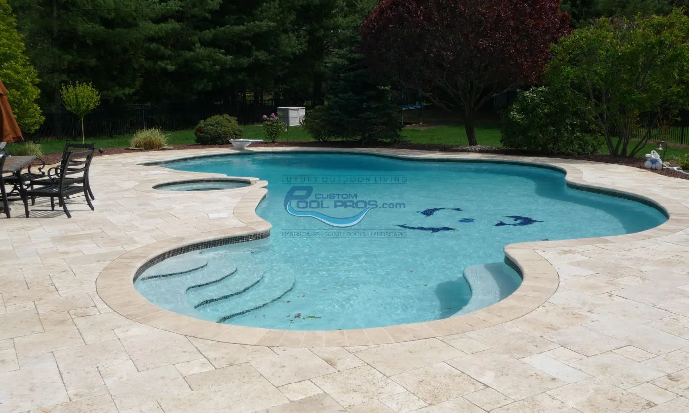 inground freeform pool with travertine pool patio deck backyard, modern swimming pool