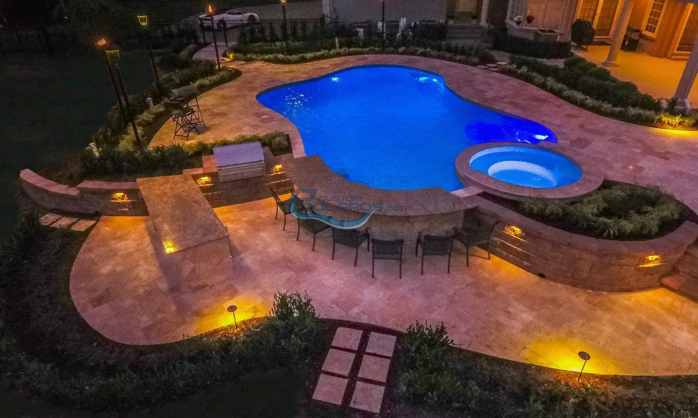 freeform inground gunite concrete pool with spa swim up bar at night with lights installation, custom inground pools, inground pool