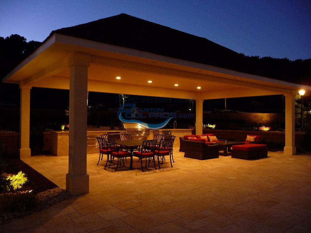 pavilion seen in evening with lights, chairs and sitting area patio, luxury swimming pools